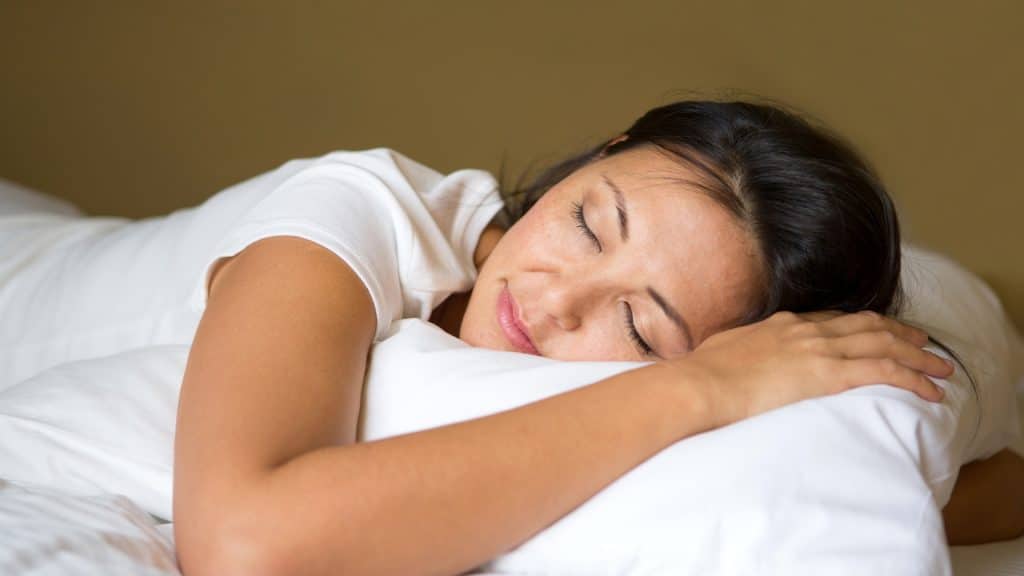 Person resting on white pillows.